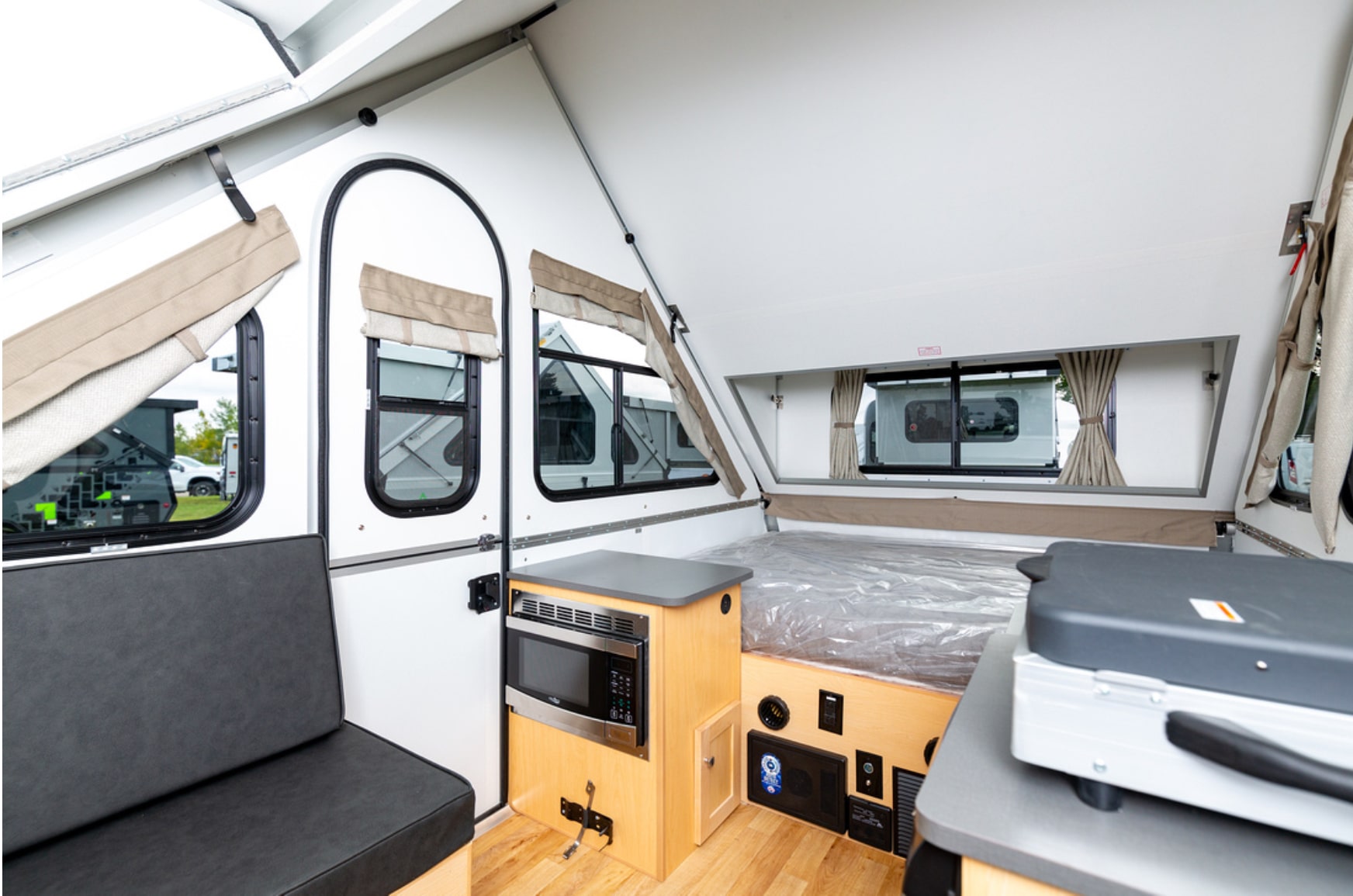 The interior of an rv with a bed and a desk.