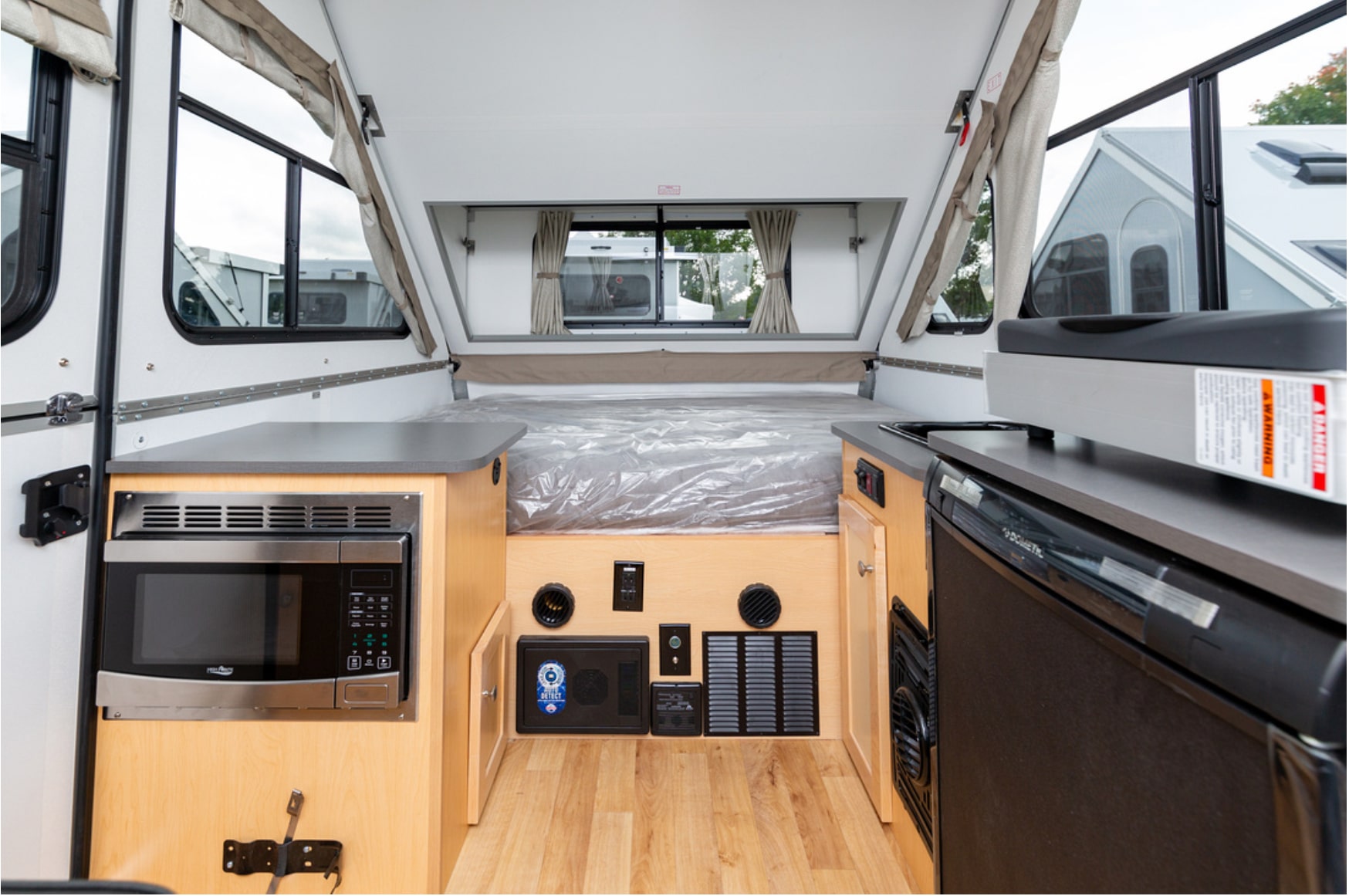 The interior of an rv with a microwave and sink.