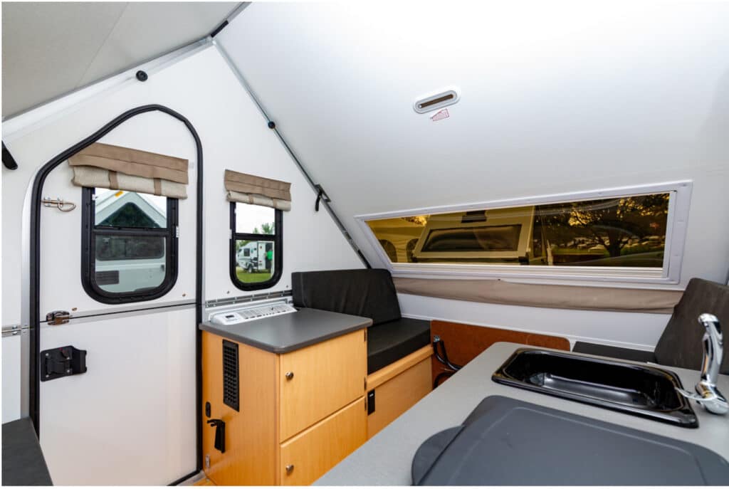 The interior of an rv with a sink and a stove.