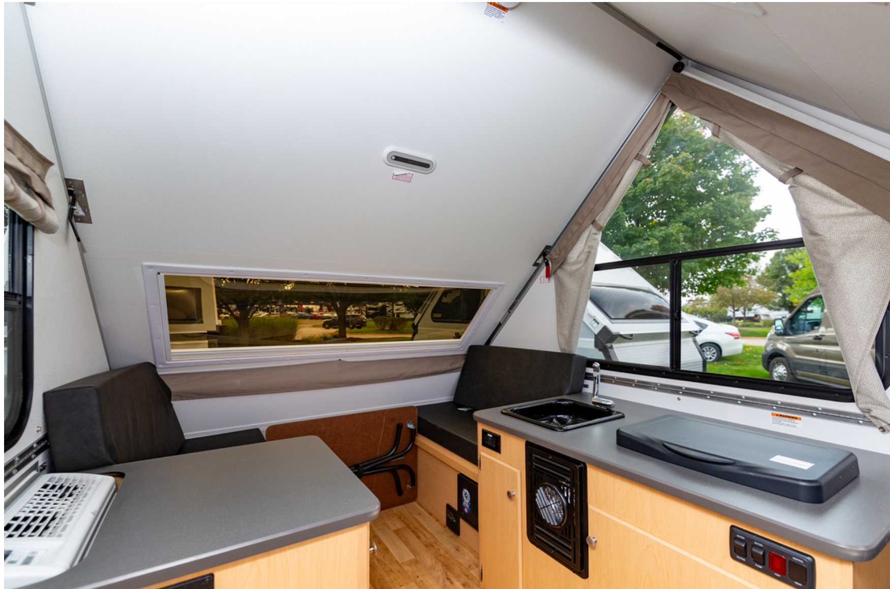 The interior of an rv with a table and chairs.