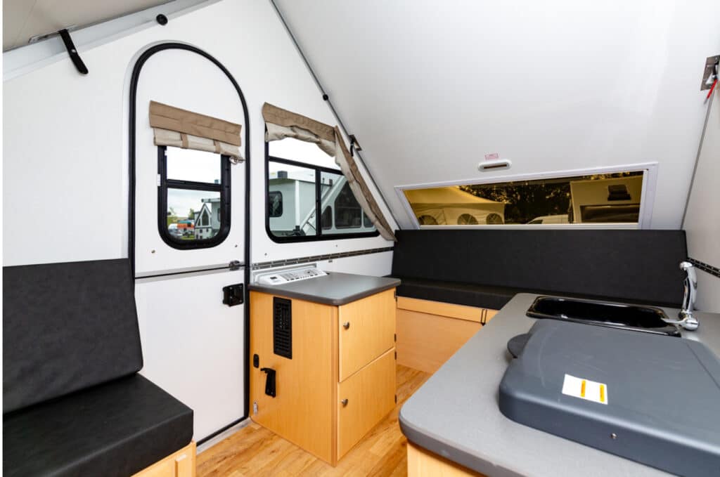 The interior of an rv with a sink and counter top.