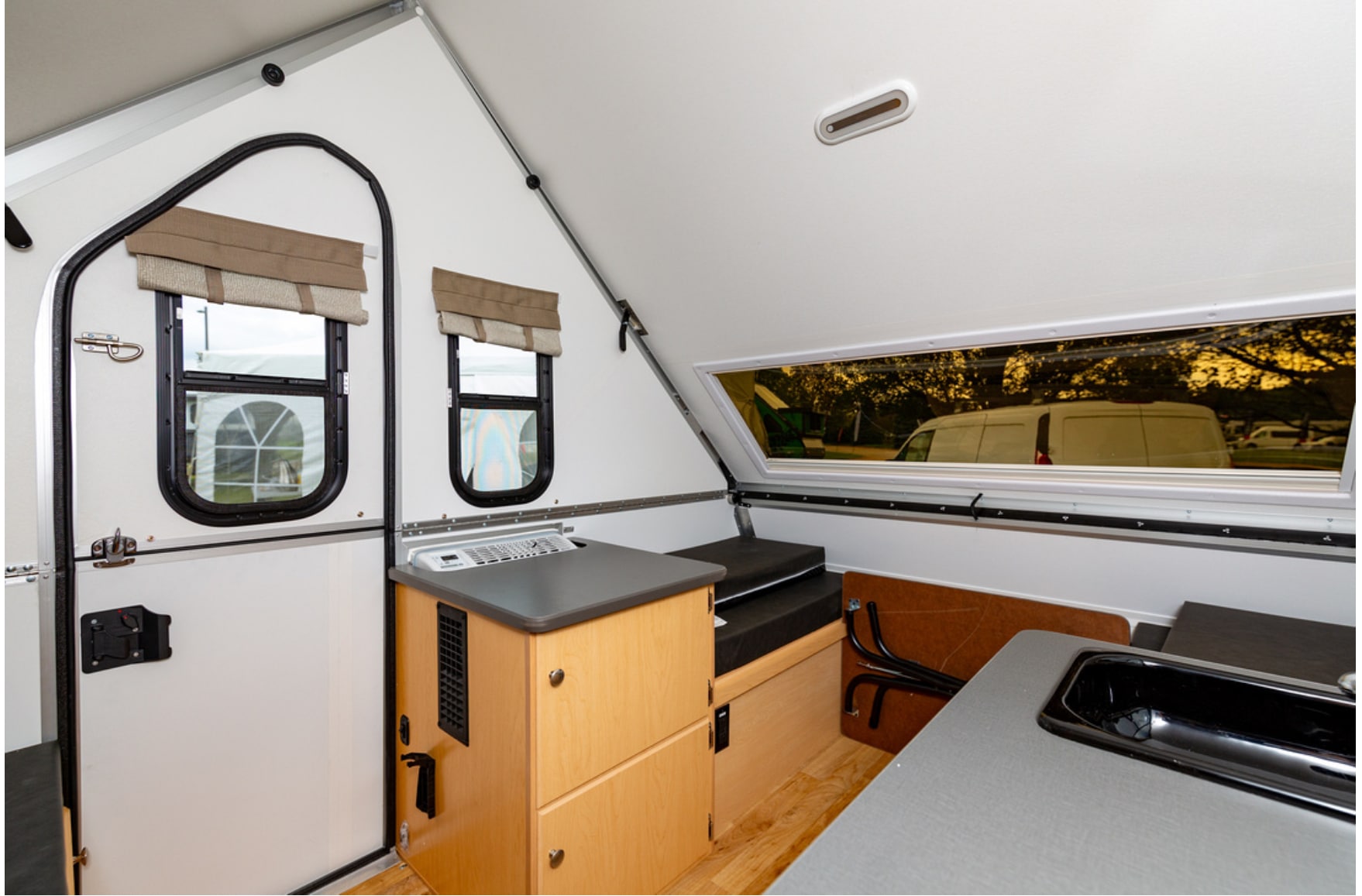 The interior of an rv with a sink and a stove.