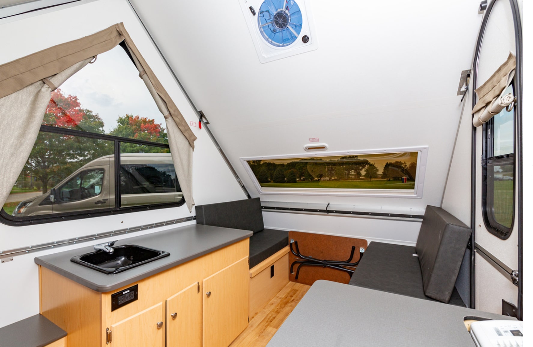 The interior of an rv with a sink and a window.