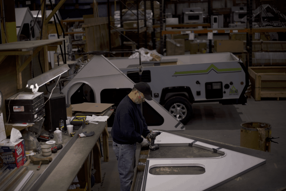 A man is working on a truck in a factory.