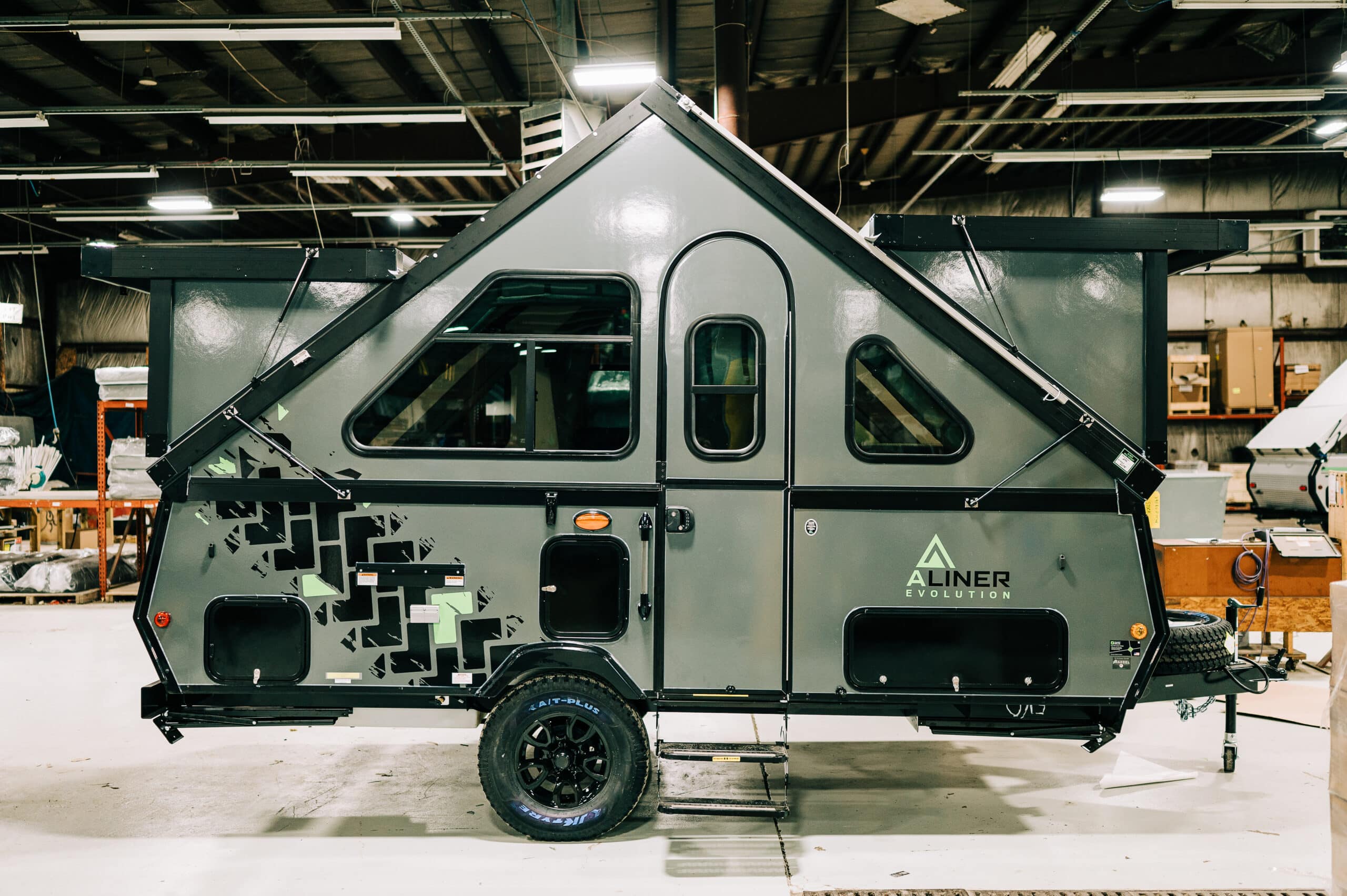 A small camper trailer with the door open.