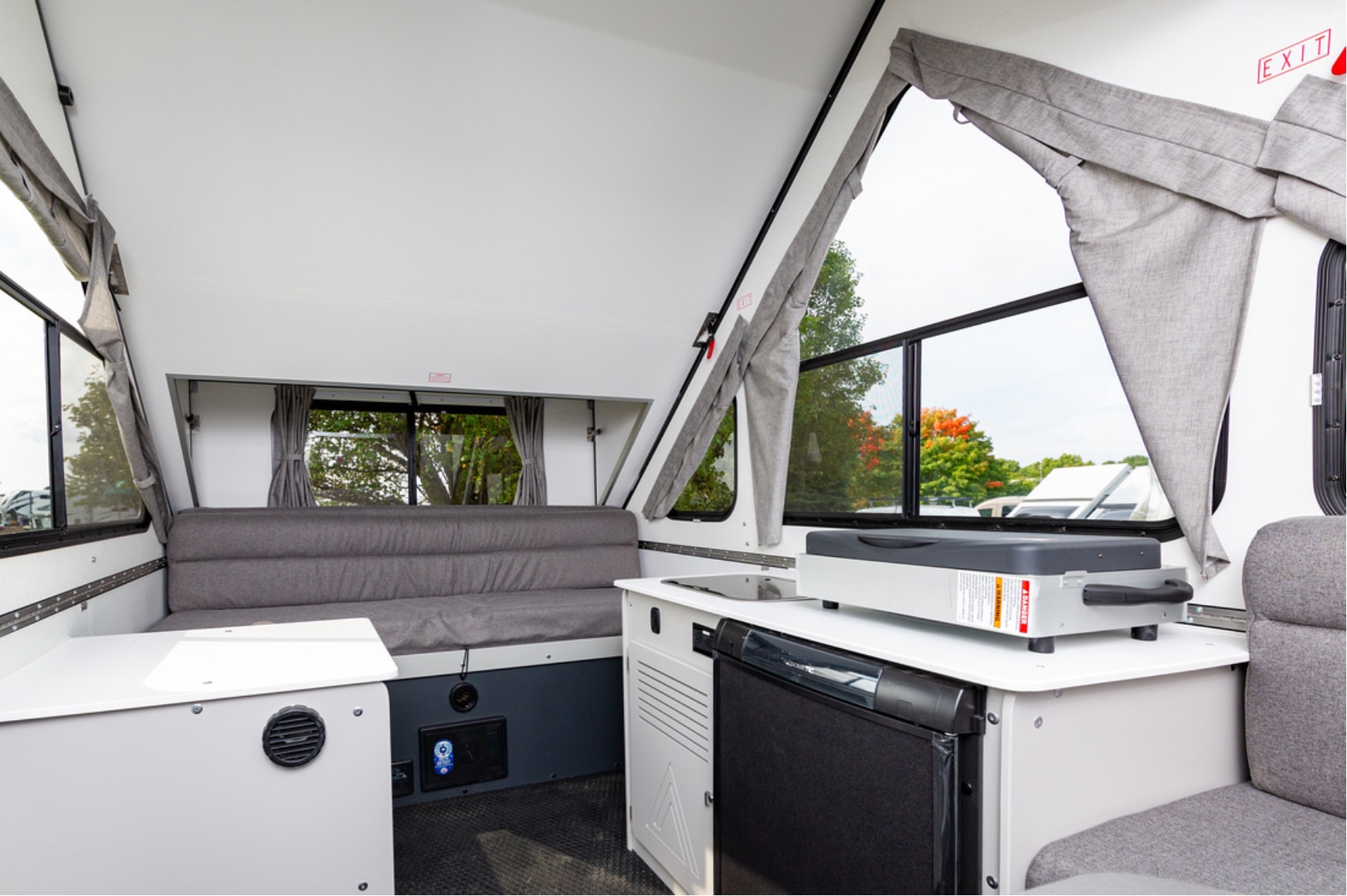 The interior of an rv with a sink and a refrigerator.