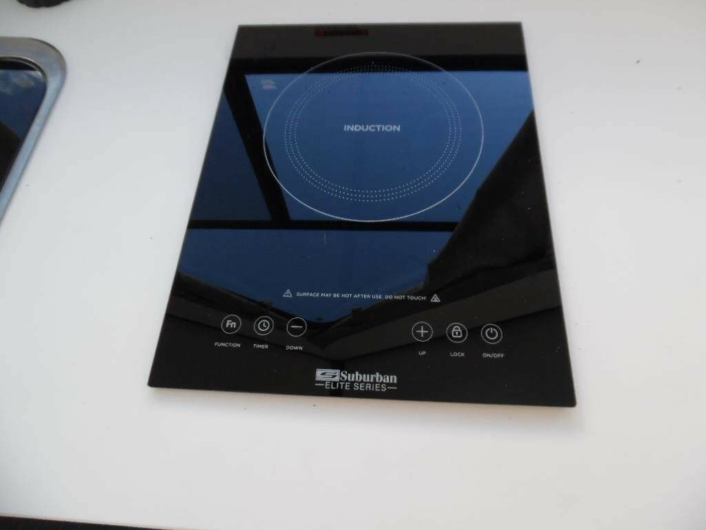 Portable induction cooktop with control panel.