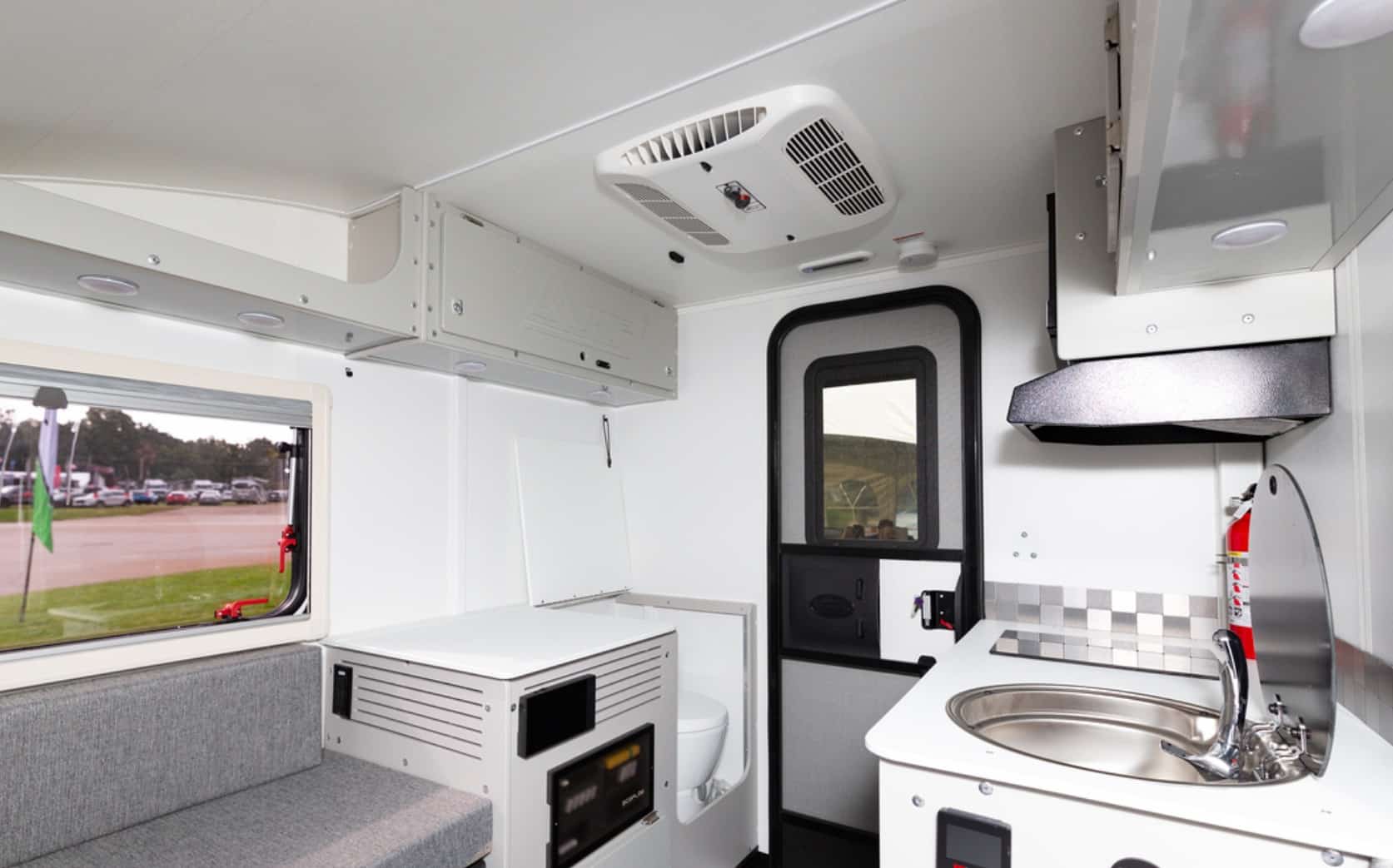 Interior view of a compact camper van with kitchenette and seating area.