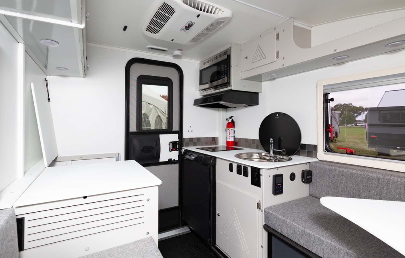 Interior of a modern camper van with a kitchenette and seating area.