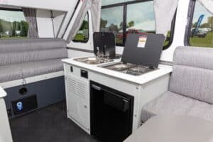 The interior of an rv with a couch and sink.